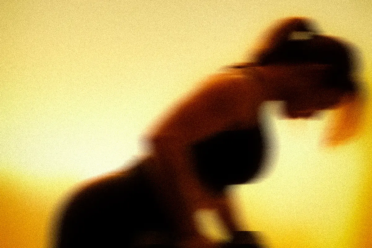A member driving forward mid-exercise, lit from behind in amber