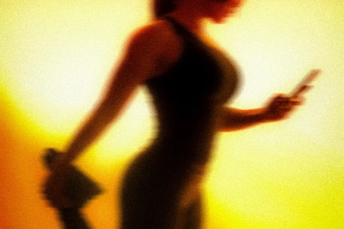 A member holding a standing quad stretch in amber light