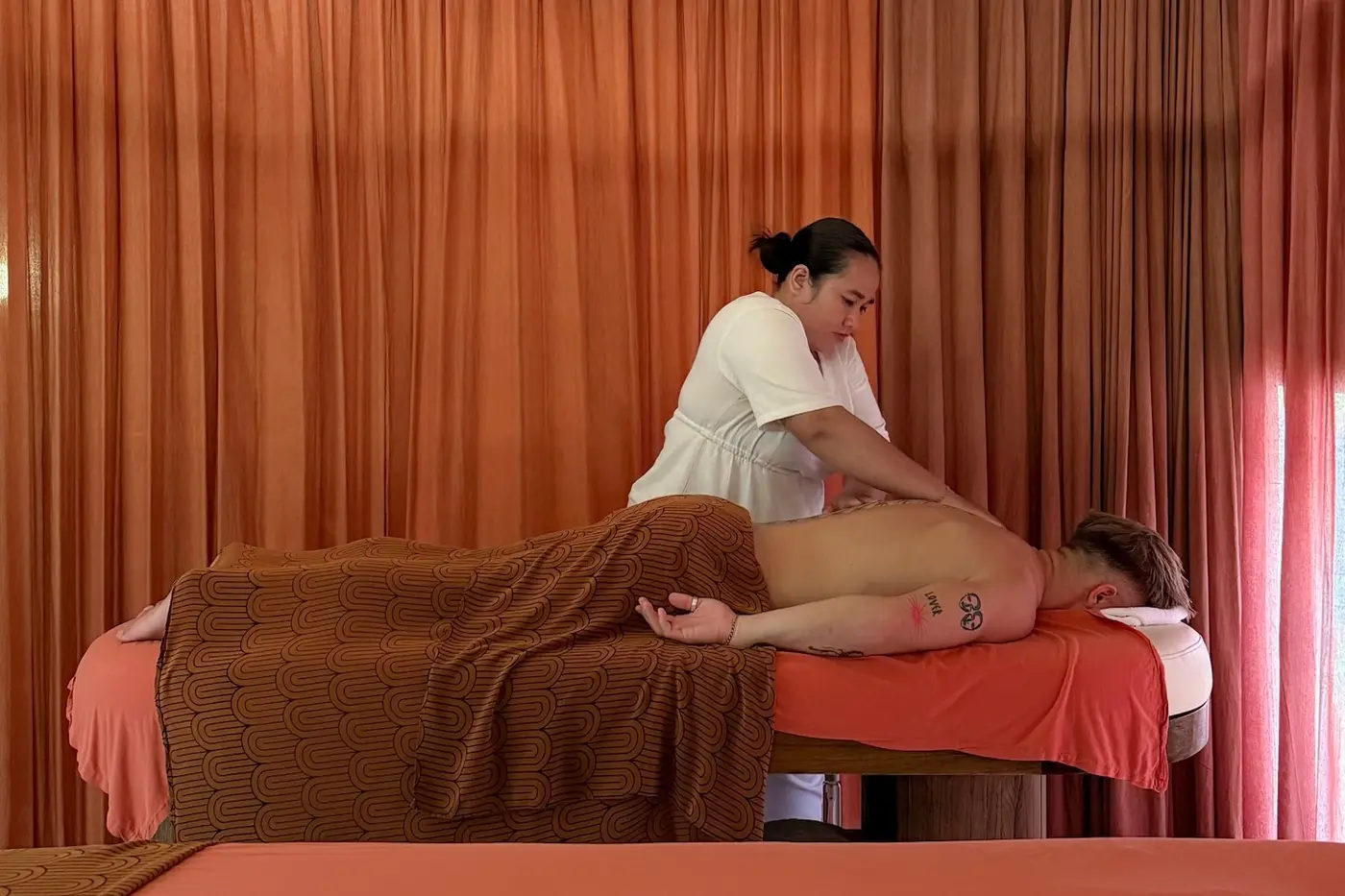 A therapist working on a guest in the terracotta treatment room at ASAI Spa